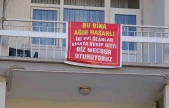 Ağır hasarlı pankartı asılan binayı görenler bir daha bakıyor