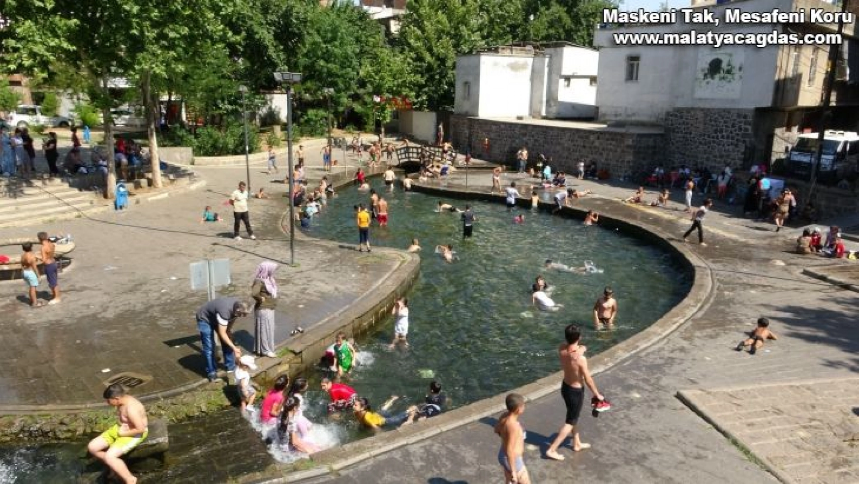 Diyarbakır'da sıcaktan bunalan çocuklar süs havuzlarını doldurdu