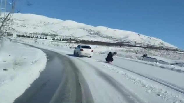 Araca bağladığı kızağı metrelerce çekti