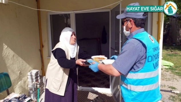 Din görevlisi belde de yaşayan yaşlılara iftar yemeği dağıtıyor