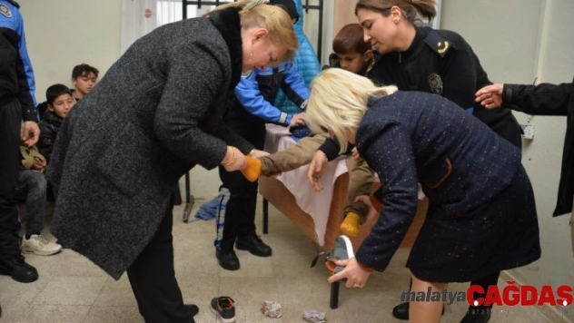Islak çorabını çıkardığı öğrencinin ayağını mendille kuruladı