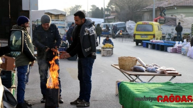 Pazarcılar soğuktan korunmak için soba kurdu