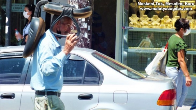 Sıcaktan korunmak isteyen vatandaştan ilginç yöntem: Kafasının üstünde koltukla yürüdü
