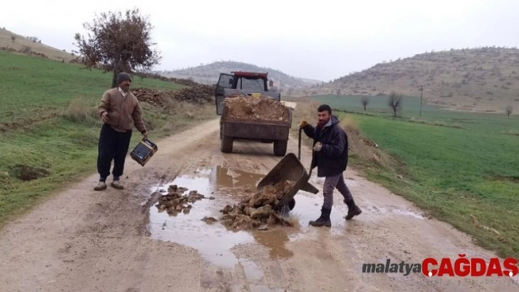 Yolda oluşan çukurları köylüler kapatıyor